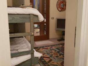 a room with a bunk bed and a television at Casa Camilla in Polpenazze del Garda