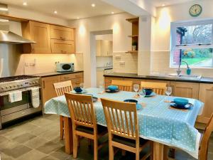 a kitchen with a table with a blue table cloth at Lyndale House - Exclusive use, self catering, fpventures Stroud in Stroud