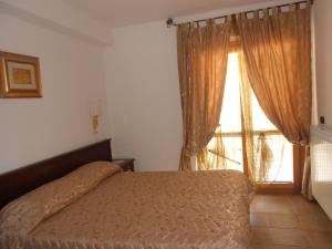 a bedroom with a bed and a large window at Hotel Vitalba in Rocca di Mezzo