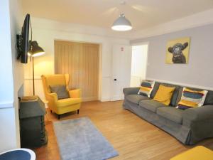 a living room with a couch and a yellow chair at Lyndale House - Exclusive use, self catering, fpventures Stroud in Stroud