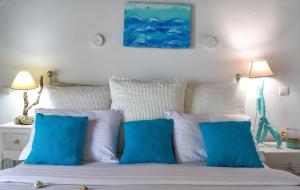 a bedroom with blue and white pillows on a bed at Andriana in Agios Georgios