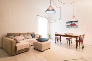 ein Wohnzimmer mit einem Sofa und einem Tisch in der Unterkunft Casa degli Affreschi a Palazzo Lungarini in Palermo
