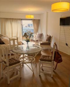 a living room with a glass table and chairs at Cuatro Estaciones in San Carlos de Bariloche