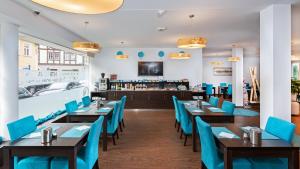 a dining room with wooden tables and blue chairs at Hotel - Stadtvilla Central in Schweinfurt