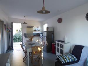 eine Küche und ein Wohnzimmer mit einem Tisch und einem Esszimmer in der Unterkunft Location au calme vue sur le canal du midi et la mer in Portiragnes