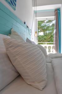 a bed with a pillow on it with a window at Andriana in Agios Georgios