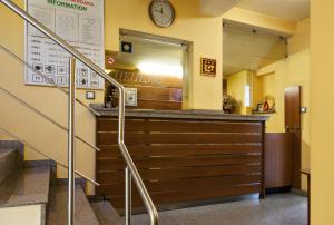 a lobby with a bar with a clock on the wall at Family Hotel Gerdjika in Plovdiv