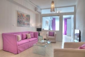 - un salon avec un canapé rose et deux chaises dans l'établissement Downtown Glyfada smart apartment, à Athènes