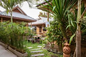a garden with a picnic table and some plants at Boutique Hotel & Restaurant, Jaidee Bamboo Huts in Chiang Mai