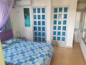 a bedroom with a blue and white bed in a room at Lapiroguevilla[Tourist resident] in Pereybere