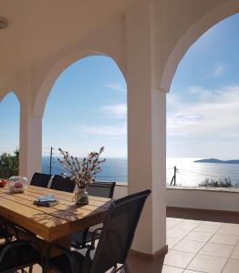 uma sala de jantar com uma mesa e vista para o oceano em villa hena em Batsi