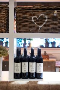 cuatro botellas de vino sentadas en un estante en Hotel Heer Hugo, en Heerhugowaard