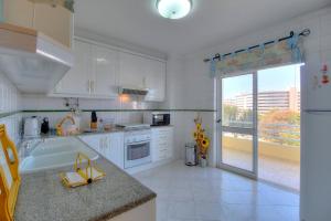 クアルテイラにある3 Bed Apartment Vilamoura Centerの白い家電製品付きのキッチン、大きな窓