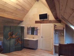ein Badezimmer mit Waschbecken und einem Fernseher an der Wand in der Unterkunft Casa La Palma II La Courmellette in Soissons