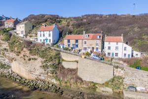 een groep huizen aan de zijkant van een klif bij Ravenscraig House in Staithes