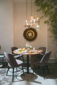 mesa de comedor con sillas y lámpara de araña en VEINTIUNO Emblematic Hotels - Adults Only en Las Palmas de Gran Canaria