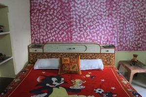 een kleine slaapkamer met een bed met een rode deken bij Tanu's homestay in Jodhpur
