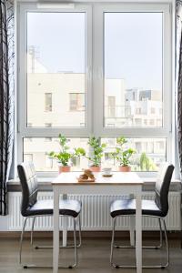 een witte tafel en twee stoelen voor een raam bij Airport Residence ORANGE in Warschau