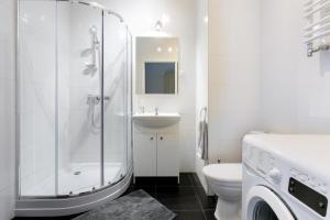 een badkamer met een douche, een toilet en een wastafel bij Airport Residence ORANGE in Warschau