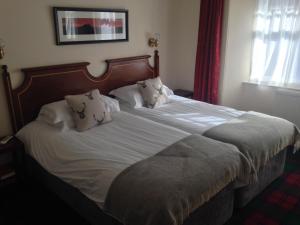 A bed or beds in a room at Highlander Inn 