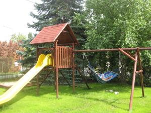 a playground with two swings and a slide at Schieszl Apartments Zamárdi 1 in Zamárdi