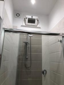 a bathroom with a shower with a tv on the wall at La Terrazza in Marsala