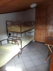a room with three bunk beds and a cabinet at Condominio La Betulla in Campo di Giove