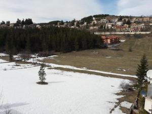 a snow covered field with a town in the background at Condominio La Betulla in Campo di Giove