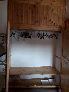 a room with a wooden cabinet with cups and hangers at Condominio La Betulla in Campo di Giove