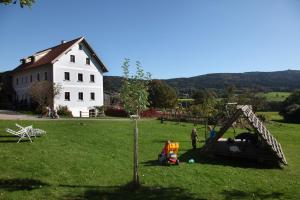 Eine Gruppe von Menschen spielt auf einem Feld mit einem Haus in der Unterkunft Hanauerhof in Schönsee