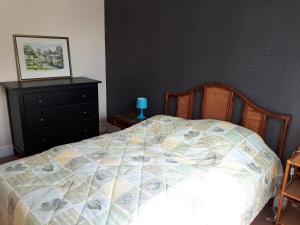 una camera con un letto e un comò con una trapunta di Idéal Panorama du Tréport a Le Tréport