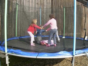 two women and a child playing on a trampoline at Hanauerhof in Schönsee