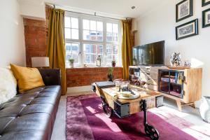 uma sala de estar com um sofá e uma televisão em Cocoa Summer em York
