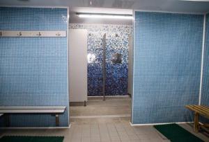bagno con pareti piastrellate blu e doccia di Albergue Municipal San Cipriano ad Ayegui