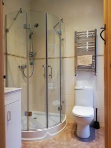 a bathroom with a toilet and a glass shower at Ewich House B&B in Crianlarich