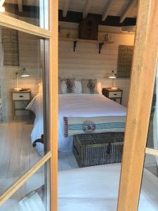 a bedroom with a bed in a wooden cabin at Maison & Tartine in Colombey-les-deux-Églises