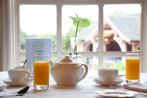 a table with a tea pot and glasses of orange juice at Goldstone Hall Hotel in Market Drayton +22 photos