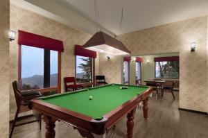 a billiard room with a pool table and some windows at Honeymoon Inn Shimla in Shimla