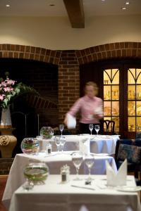 a man running in a room with tables with wine glasses at Goldstone Hall Hotel in Market Drayton
