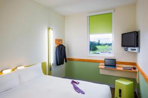 Schlafzimmer mit einem Bett und einem Schreibtisch mit einem Laptop in der Unterkunft ibis budget Hamburg St Pauli Messe in Hamburg
