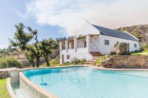 a house with a swimming pool in front of a house at Druk My Niet Wine Estate in Paarl