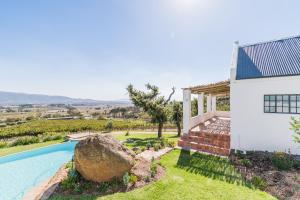 a house with a swimming pool next to a building at Druk My Niet Wine Estate in Paarl
