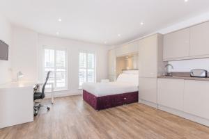 a white bedroom with a bed and a desk at Town or Country - Canute Studio in Southampton