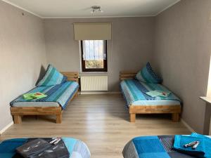 ノイヴィートにあるFerienwohnung Distelkampのベッド2台と窓が備わる小さな客室です。