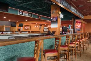 un bar avec une rangée de chaises dans un restaurant dans l'établissement Country Inn & Suites by Radisson, Fergus Falls, MN, à Fergus Falls