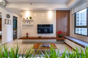 a living room with a television and a table at Hilas Masteri Thao Dien Apartment in Ho Chi Minh City