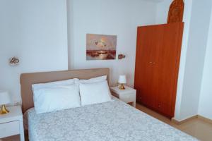Schlafzimmer mit einem Bett und einem Holzschrank in der Unterkunft Sun Βy Τhe Sea 100m from the beach in Agia Pelagia