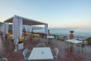 a restaurant with tables and chairs on a balcony at Grand Hotel Miramare in Taormina