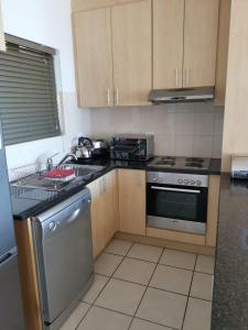 a kitchen with a sink and a stove top oven at Point Village Accommodation - Santos 40 in Mossel Bay