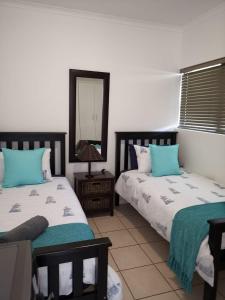 a bedroom with two beds and a mirror at Point Village Accommodation - Santos 40 in Mossel Bay